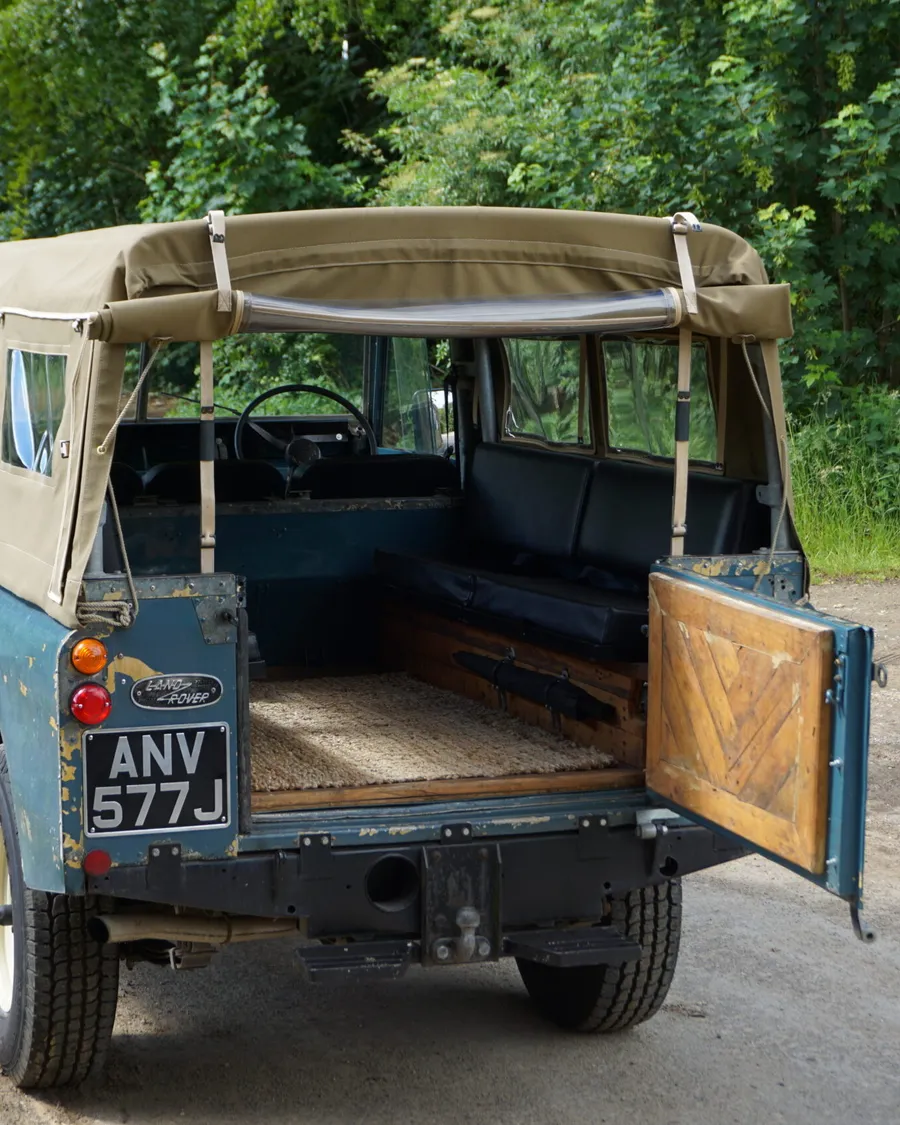 The Land Rover among honey-stone Cotswold scenery