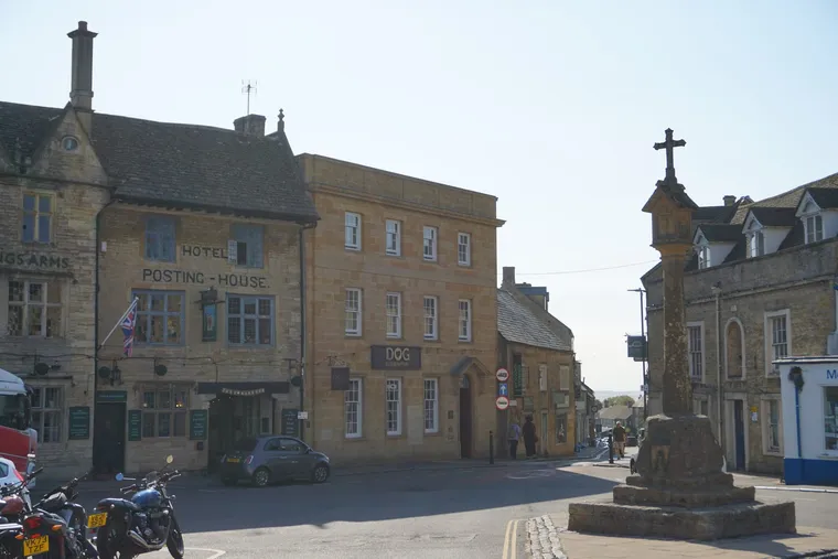 The medieval market cross and the old Kings Arms posting house in the square at Stow on the Wold